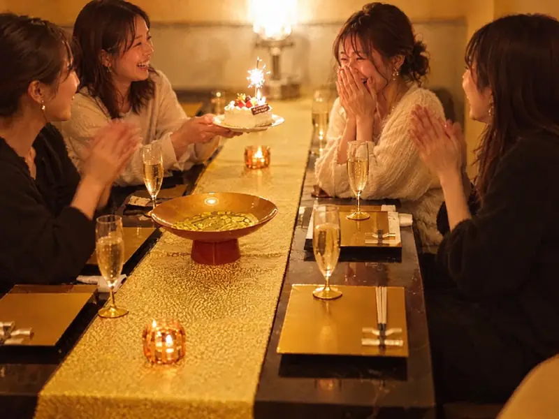 誕生日のケーキを囲んで喜ぶ女性たち（イメージ）